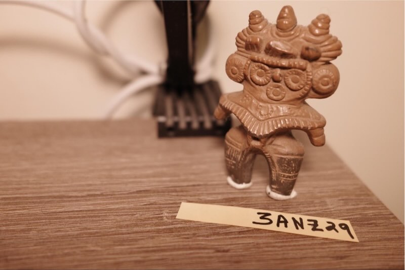 A small figurine with a paper note reading a Kakioki code